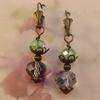 11 MM Smokey faceted crystals, 8 MM Twilight Green Crystals.  Antique bronze beadcaps and Leverback Earrings.  Pendant is approximately 1 1/4" long.