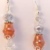 Orange Satin lantern glass beads, off-white bluish gray faceted crystals, clear iridescent bicone crystals and silver filigree, bead caps and ear wires.  Pendant is about 1 1/2" long.