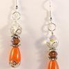 Orange Sunset teardrop beads, silver filigree bead caps and kidney ear wires make up these earrings.  Iridescent crystal bead and bicone add sparkle to these earrings which measure slightly over 1 1/4" long pendants.