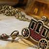 Carriage pendant is approx. 1 1/4" wide.  3/4" long.  Cinderella's red rhinestone slipper is double-faced and fastened to the carriage with a chain.  Slipper is appros. 3/4" long.  The carriage and slipper might sell as a pendant for more than the cost of the necklace.  Chain is approximately 27" 