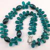 Clear Glass Jade Teardrop beads and acrylic swirl beads.
Necklace is finished with a picture frame clasp and is approx. 19" in circumference.  This is not as lightweight as a paper bead necklace, but is also not heavy or cumbersome.